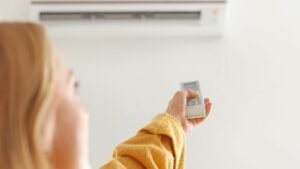 Femme qui règle la température de sa climatisation pour faire des économies